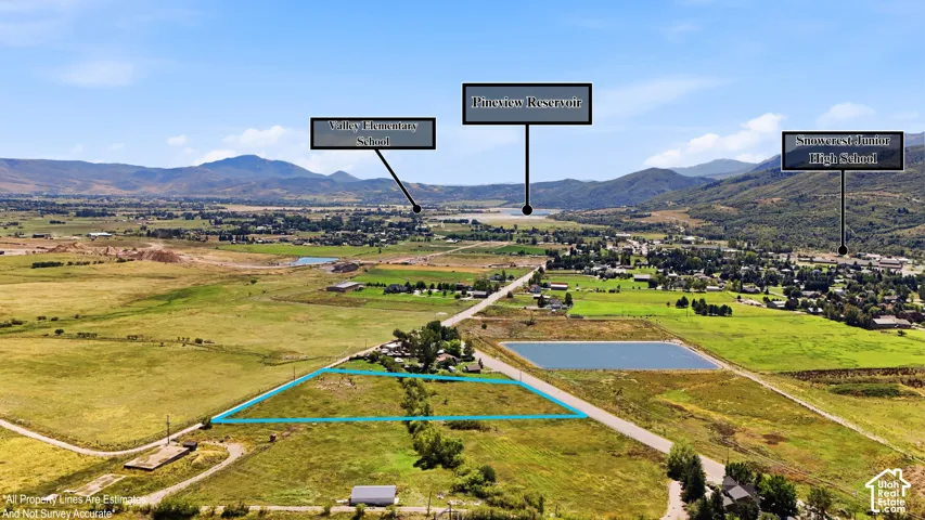 Expansive rural acreage with defined property lines, surrounded by open fields and distant mountains