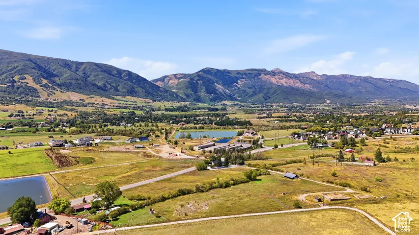 Expansive rural setting with a mountainous backdrop, featuring multiple bodies of water and varied terrain