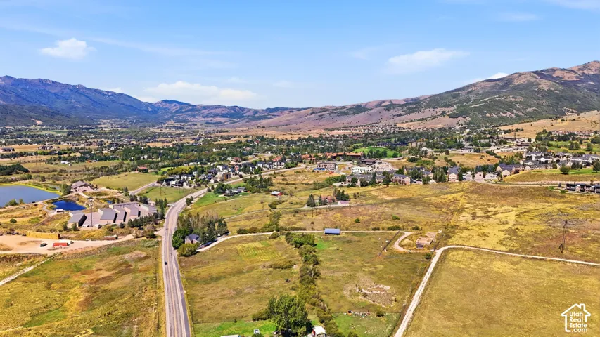 Expansive landscape featuring distant mountains, a body of water, and a paved road