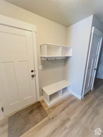 Built-in storage bench with cubbies, upper shelving, and coat hooks