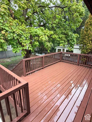 Expansive deck with wood-finish flooring and sturdy railings, offering an outdoor living area