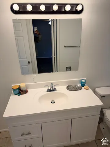 White vanity with brushed nickel hardware, integrated sink, and chrome faucet