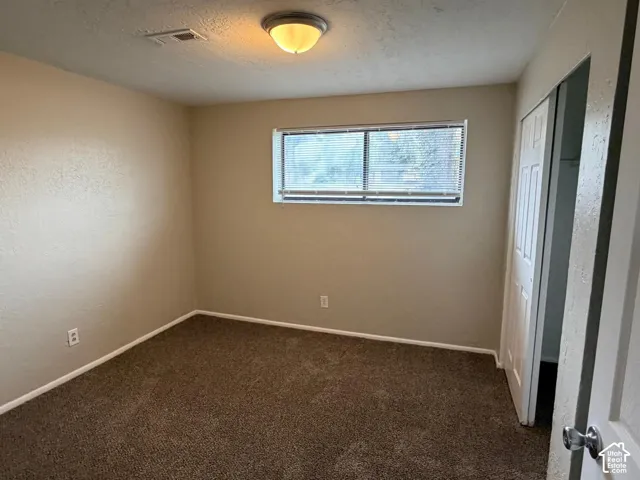 Neutral-toned walls complement the brown carpet flooring