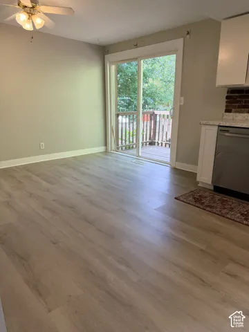 Wood-finish flooring throughout, sliding glass door, and a built-in ceiling fan with integrated lighting