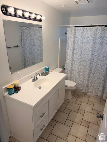White vanity with a built-in sink, chrome faucet, and rectangular mirror