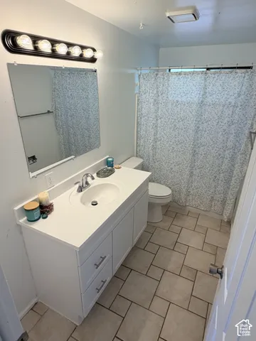 White vanity with a built-in sink, chrome faucet, and rectangular mirror