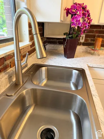 Stainless steel double basin sink with a brushed nickel pull-down faucet