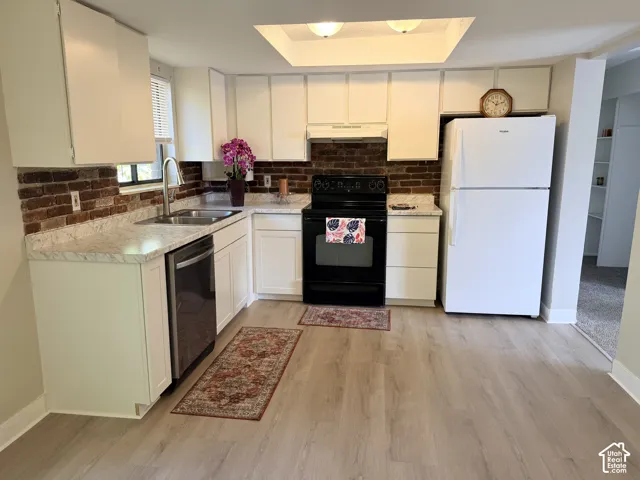White cabinetry with stainless steel hardware, stone-finish countertops, brick-finish backsplash, stainless steel sink with gooseneck faucet, and wood-finish flooring