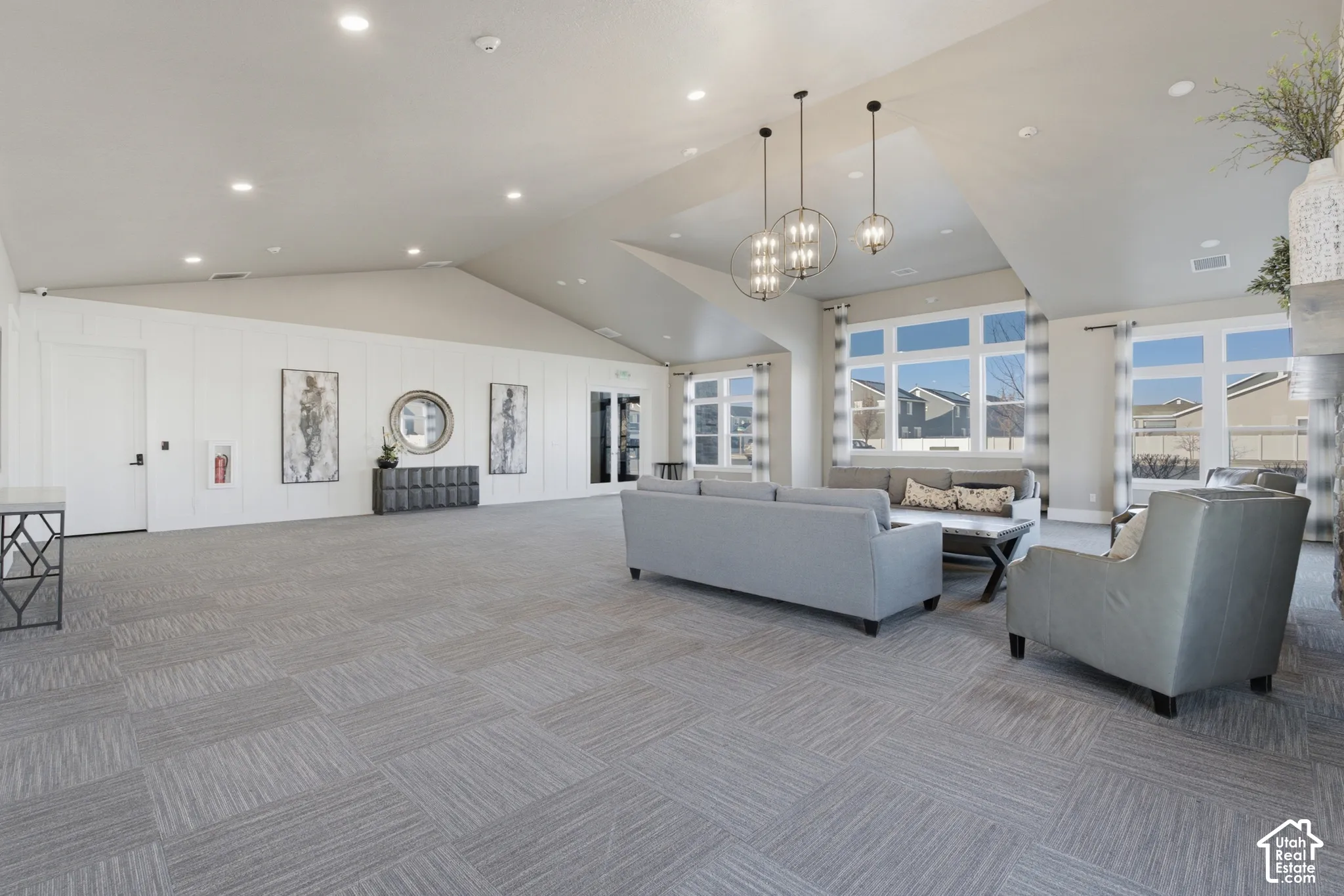 Vaulted ceilings, recessed lighting, large windows, chandelier lighting, and patterned carpet flooring