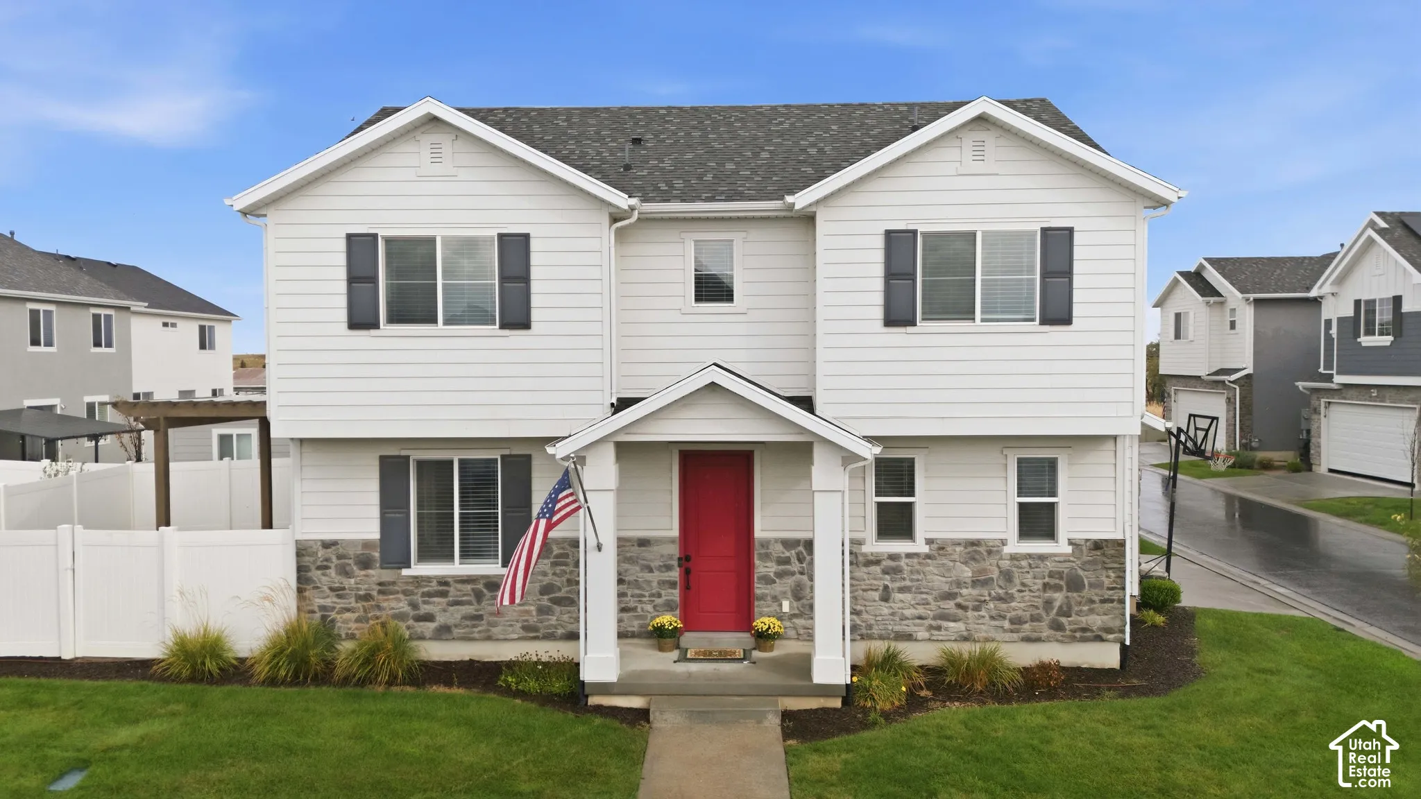 White siding facade with a red entry door