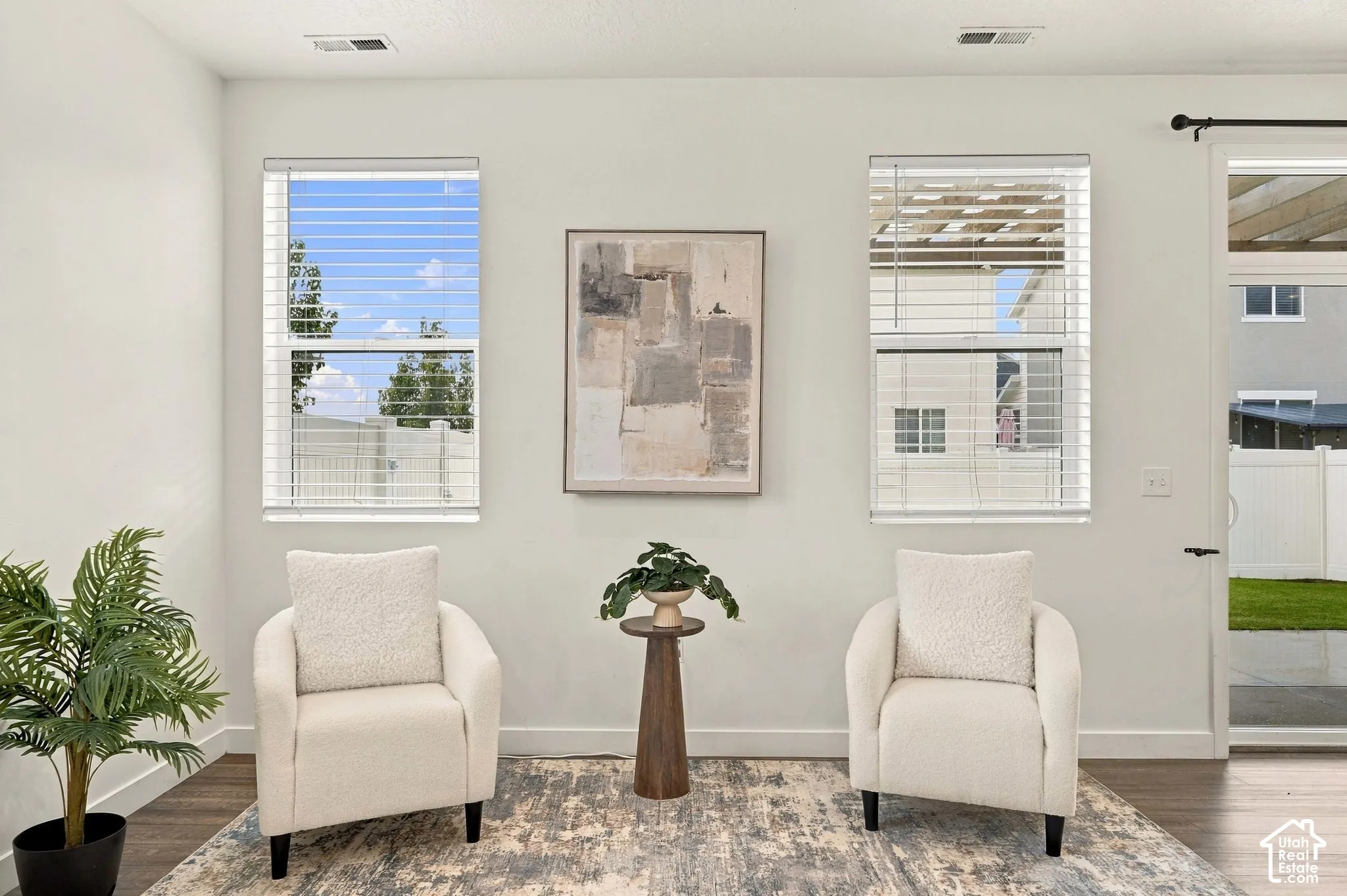 White interior walls, wood-finish flooring, and white window blinds