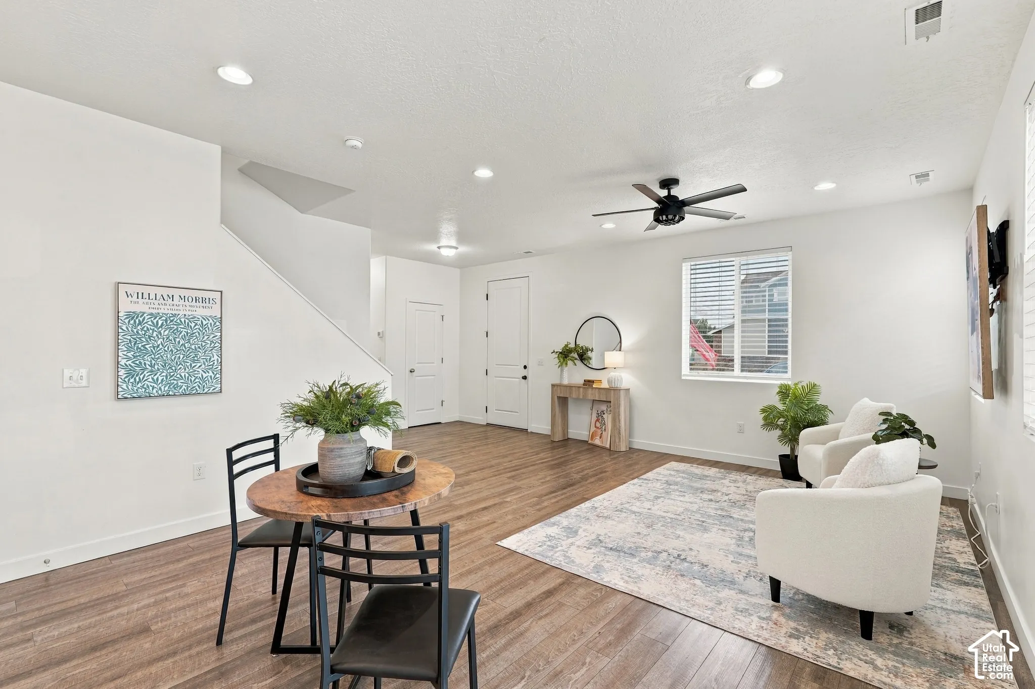 Open-concept living area featuring wood-finish flooring, recessed lighting, and a ceiling fan