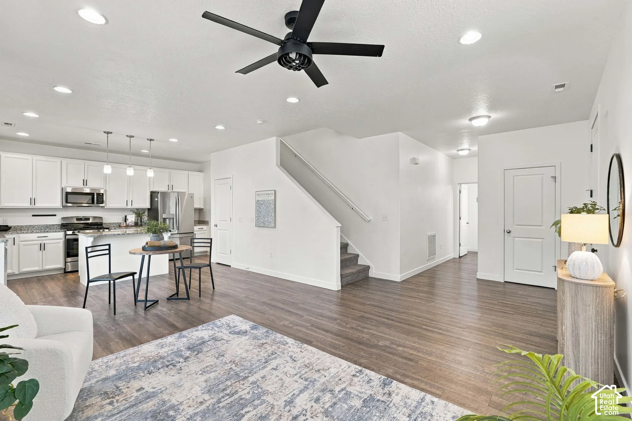 Open-concept living space with wood-finish flooring, recessed lighting, and a modern ceiling fan