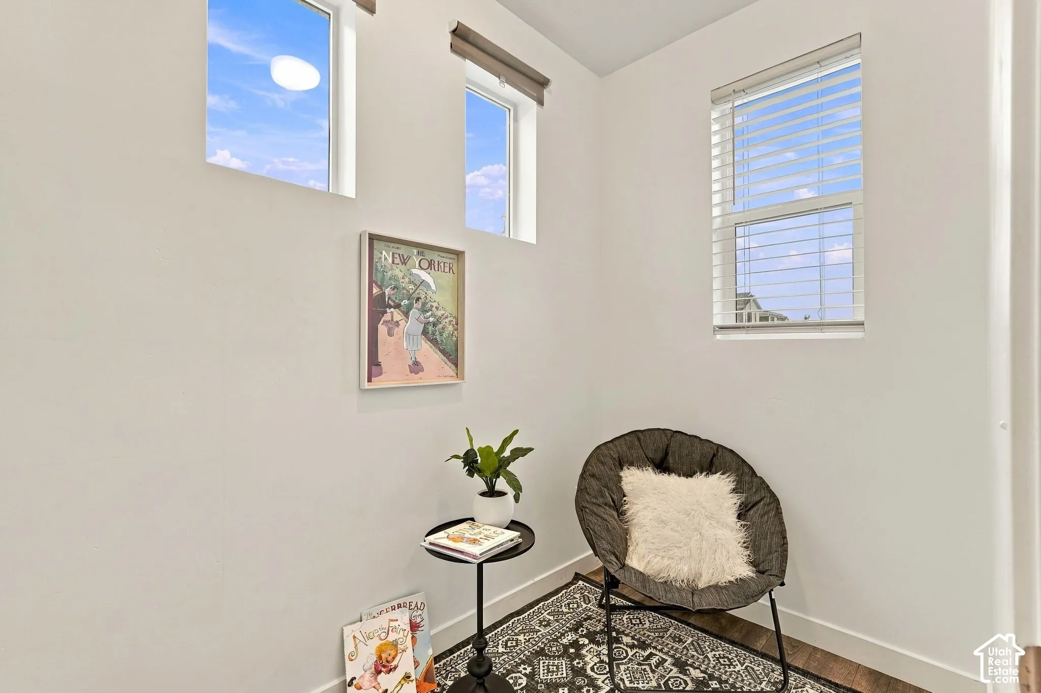 White walls with multiple windows, including transom windows, and wood-finish flooring
