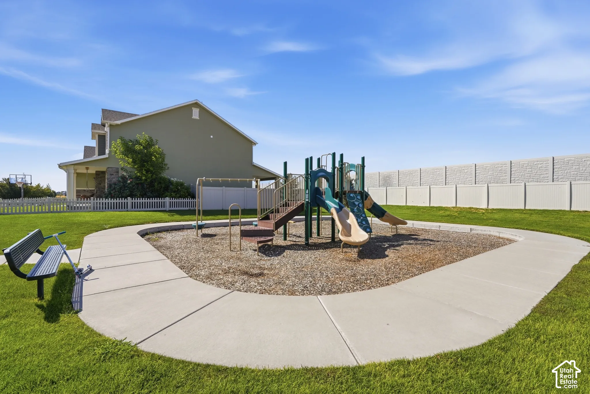 Outdoor playground with slides and climbing features, surrounded by wood chip surfacing