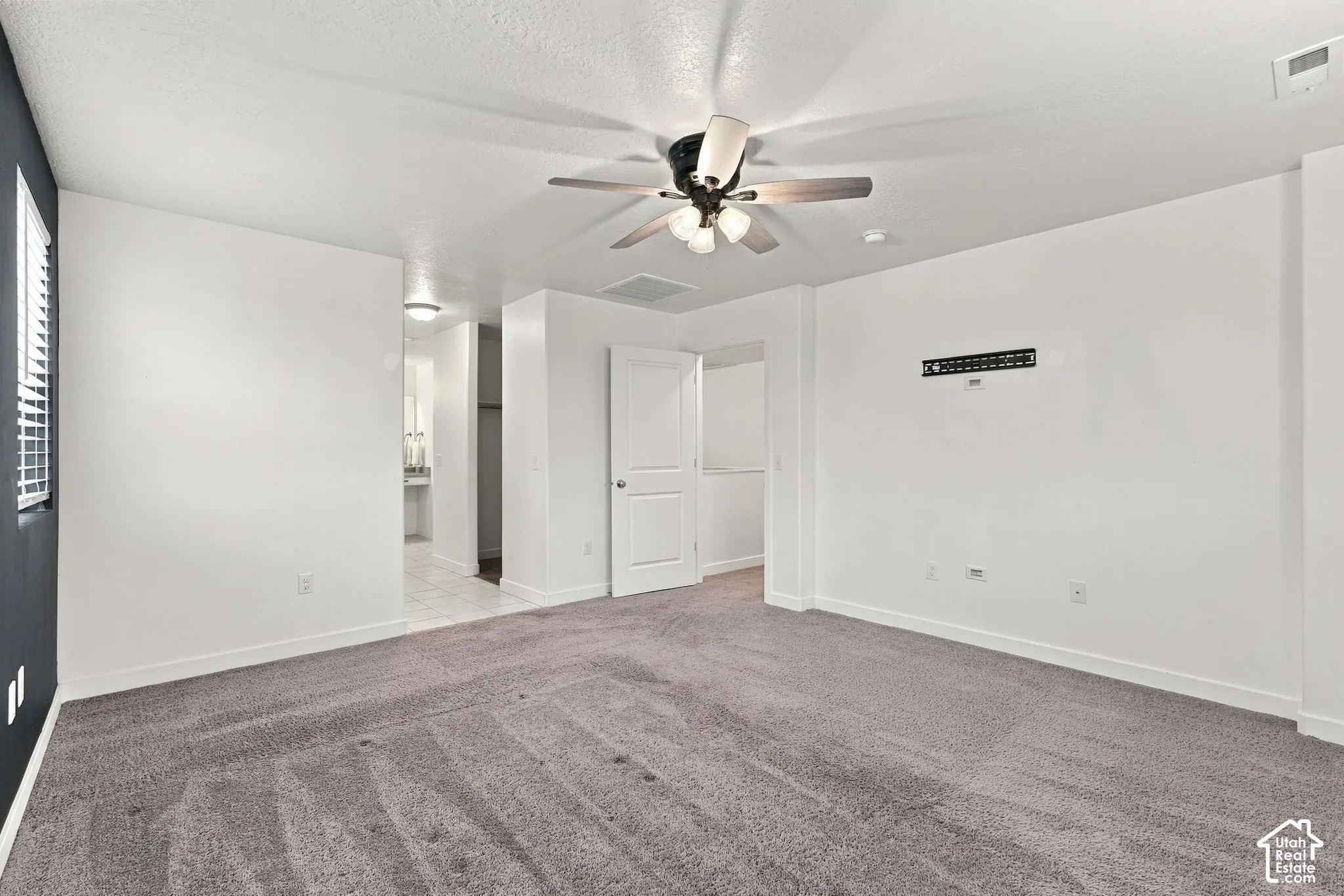 Spacious room with gray carpeting and white walls