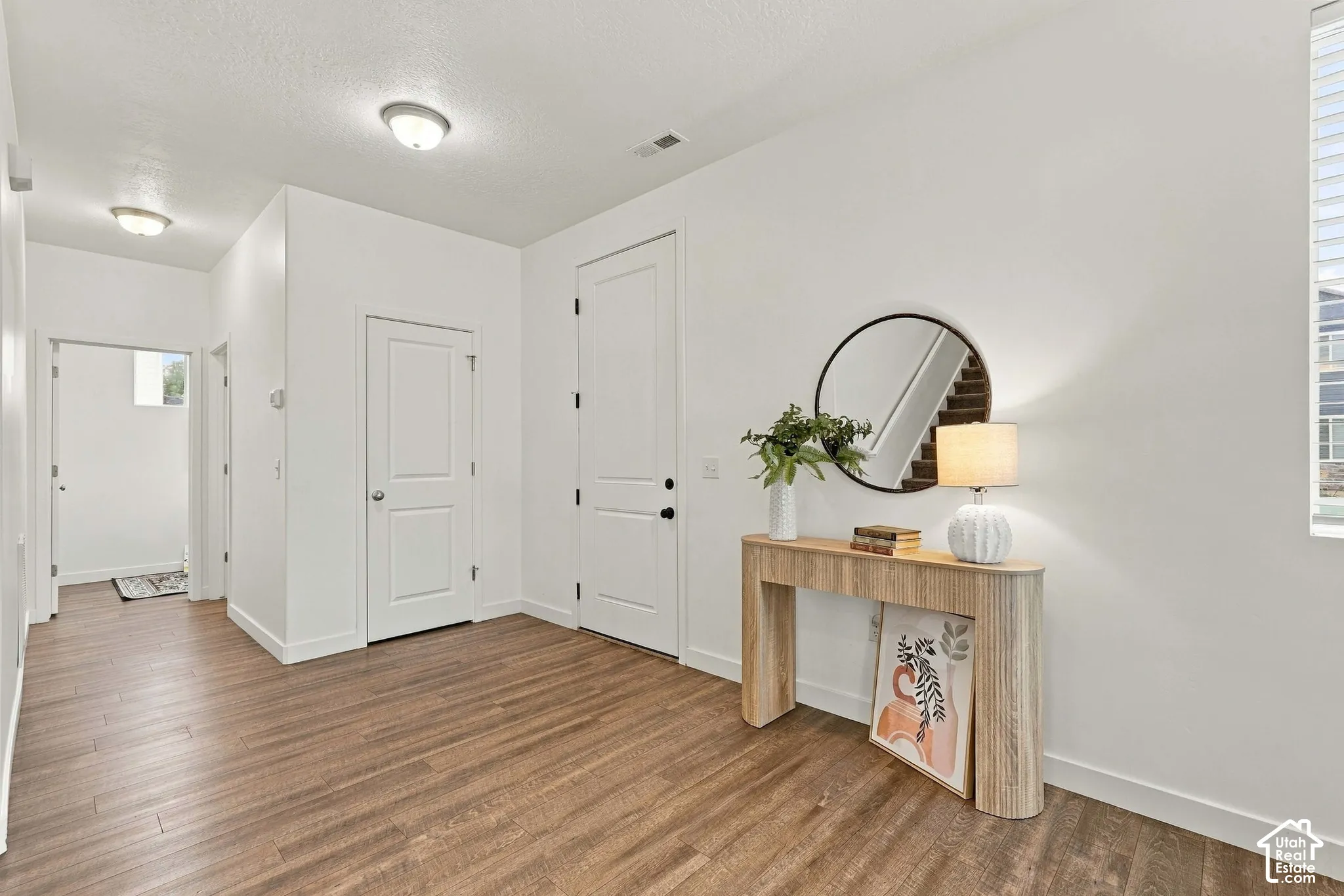Warm wood-finish flooring with white walls and trim throughout