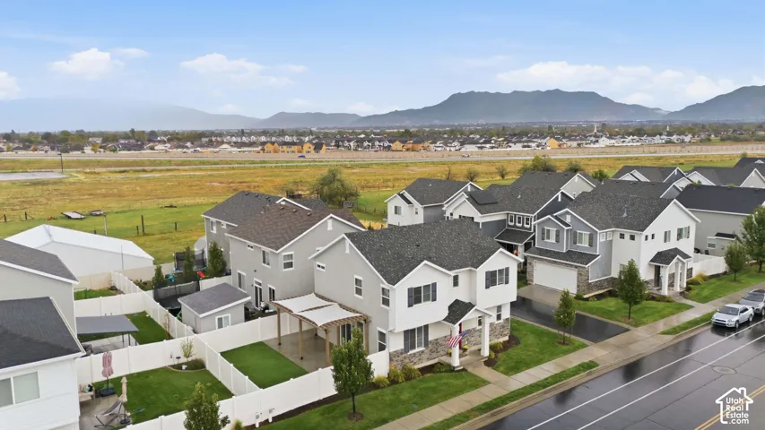 Residential neighborhood featuring a paved street, sidewalks, and a mountain backdrop