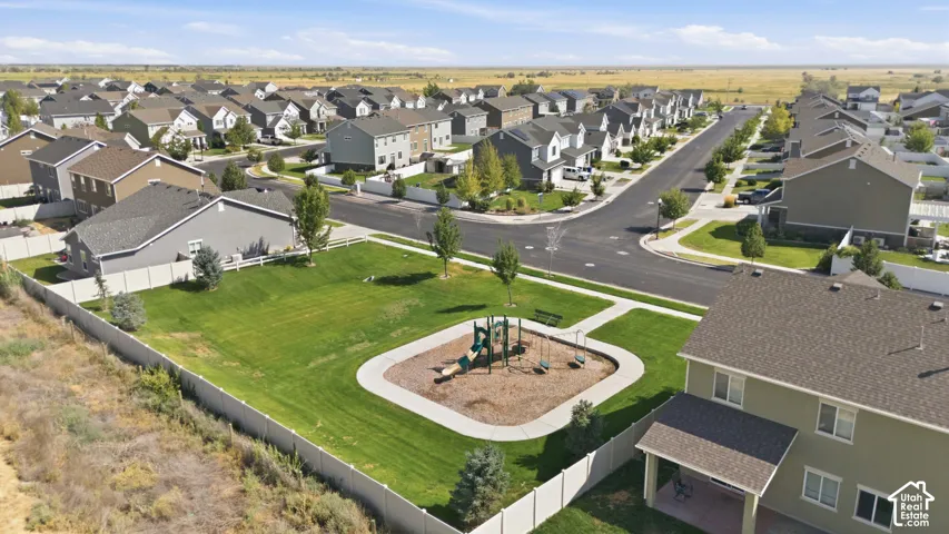 Expansive residential community featuring a central green space with a playground, paved streets, and a variety of detached homes
