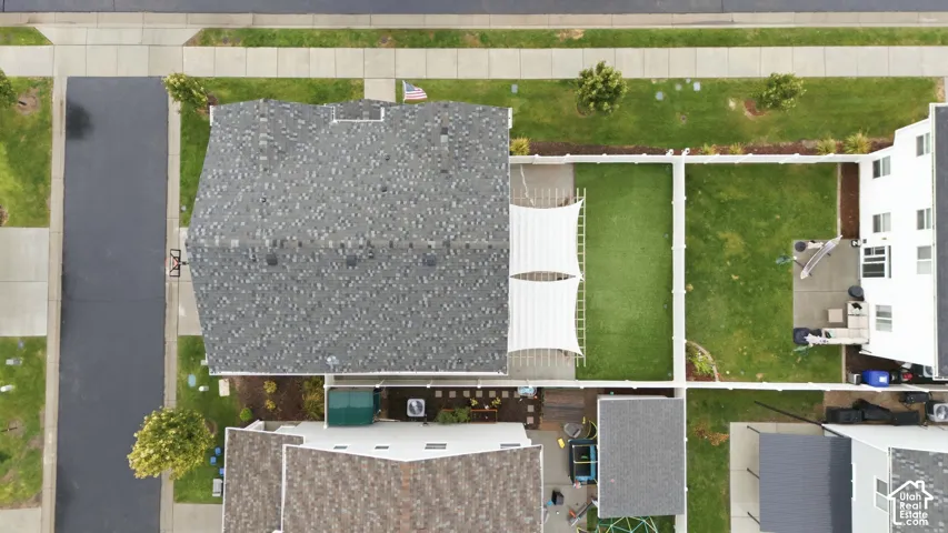 Fenced backyard with artificial turf, a white privacy fence, and a patio area