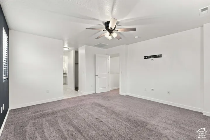Spacious room with gray carpeting and white walls
