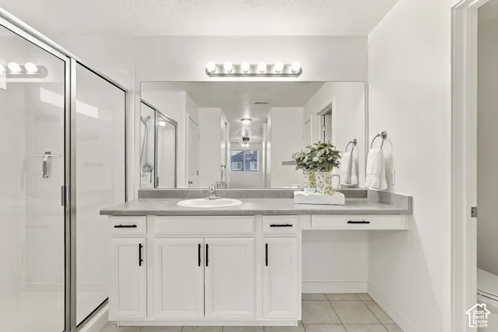 White vanity with integrated sink, gray countertop, and built-in makeup area