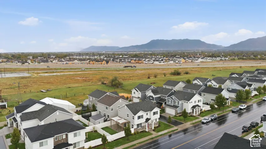 Residential street featuring multiple properties with two-story structures, attached garages, and paved driveways