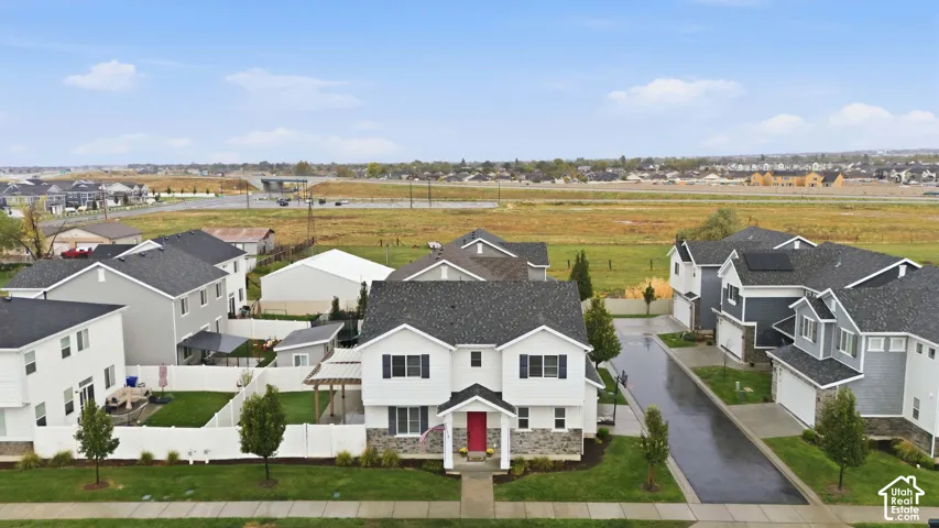 Two-story home with a dark gray shingle roof, white siding, stone veneer accents, and a red front door