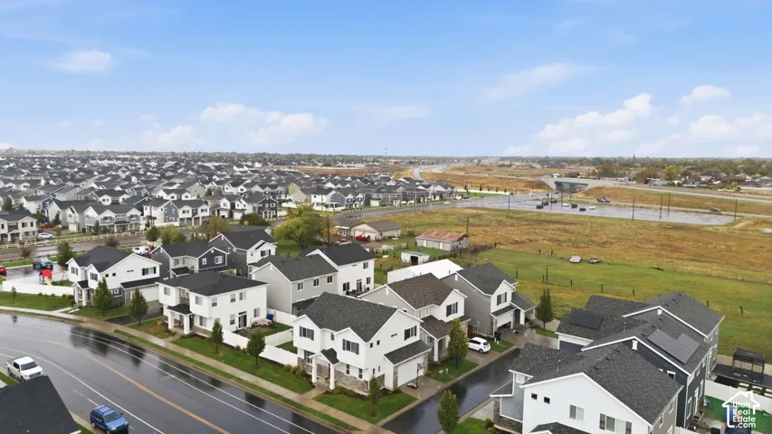 Modern suburban neighborhood featuring multiple multi-story homes with dark shingle roofs, some equipped with solar panels