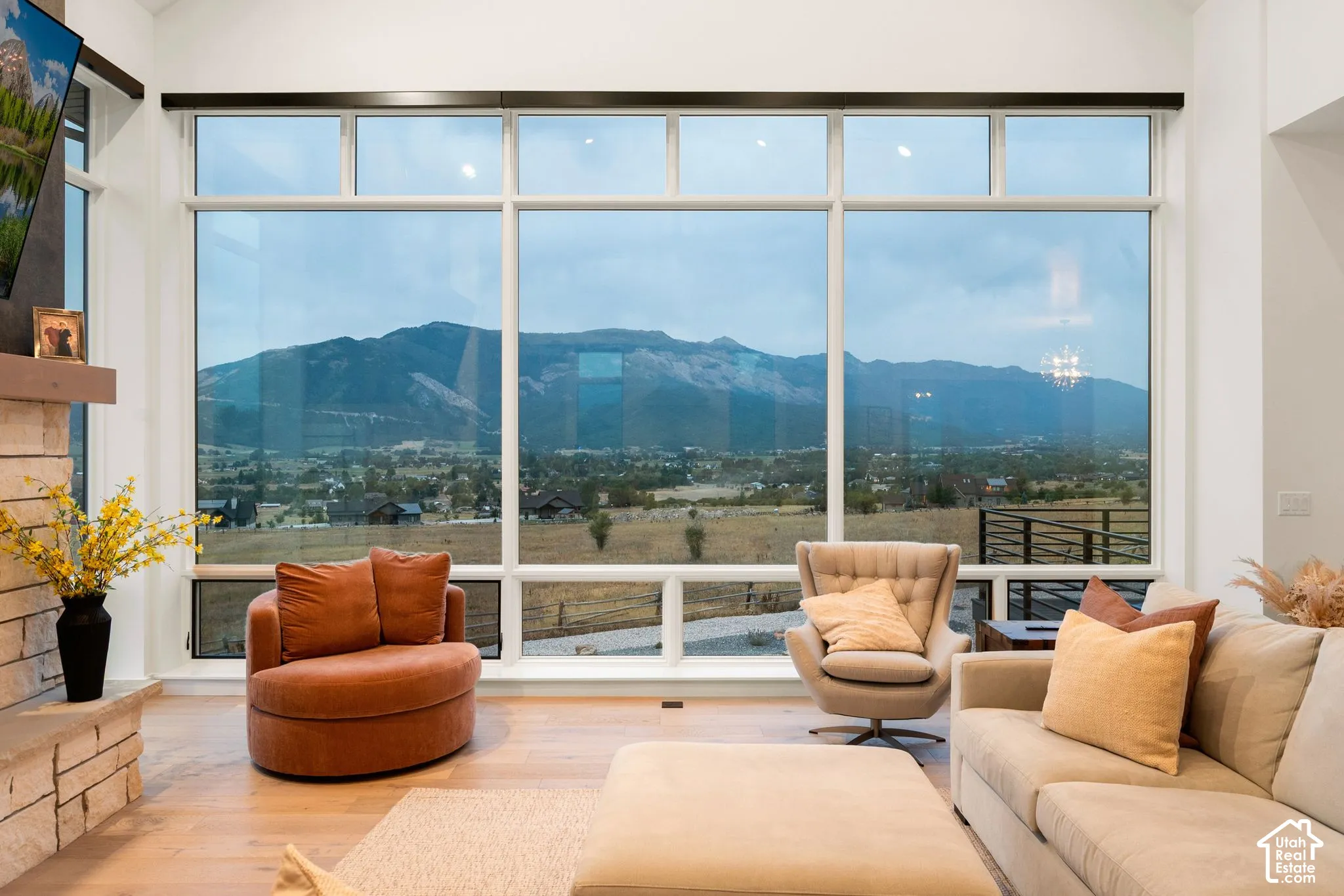 Expansive living room showcasing floor-to-ceiling multi-panel windows framing panoramic mountain and valley vistas
