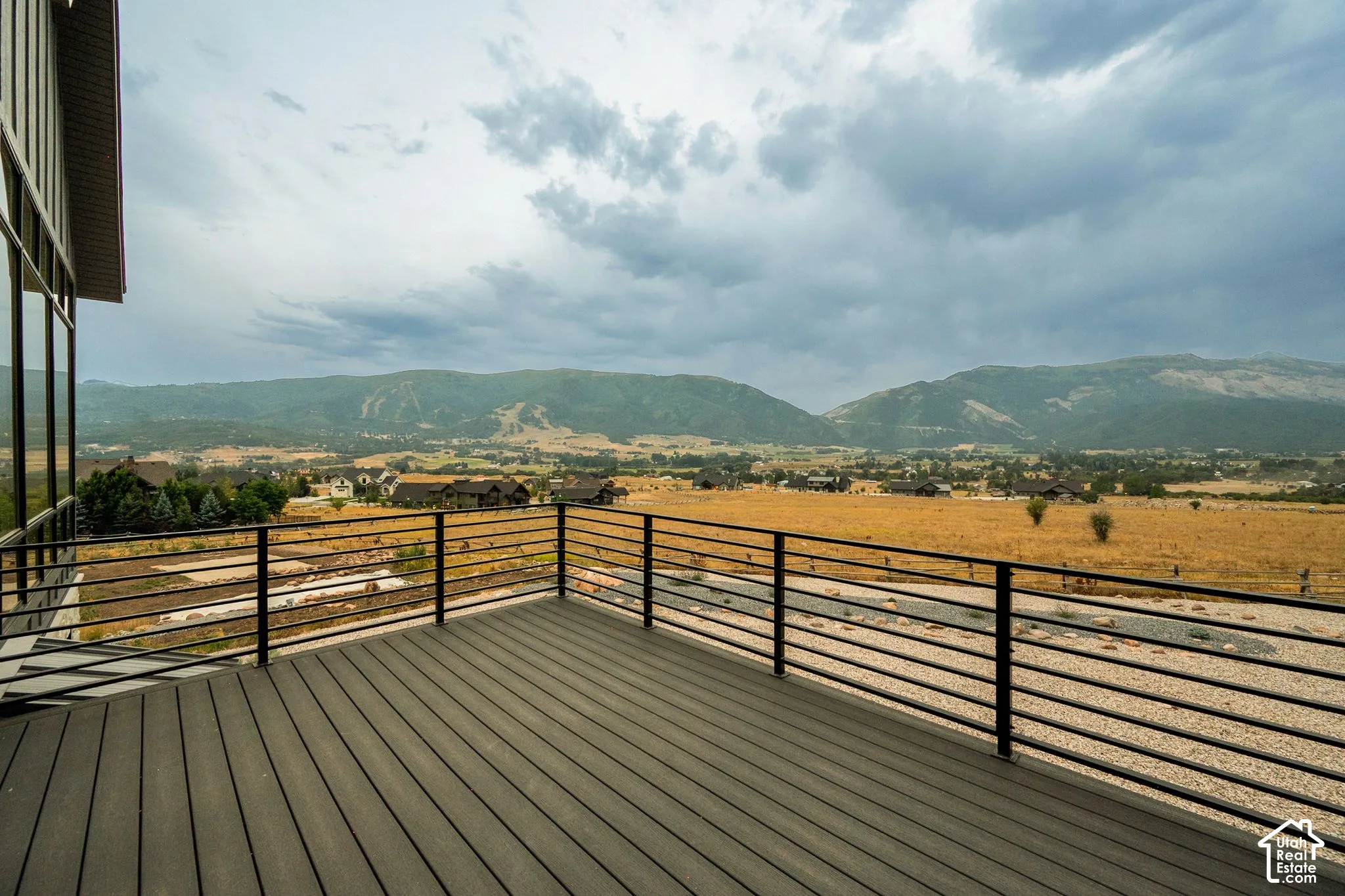 Expansive outdoor deck with composite decking, modern metal railings, and large format windows