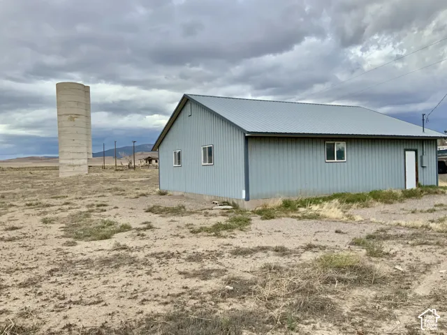 Metal-sided structure with a metal roof, multiple windows, and a side entry door