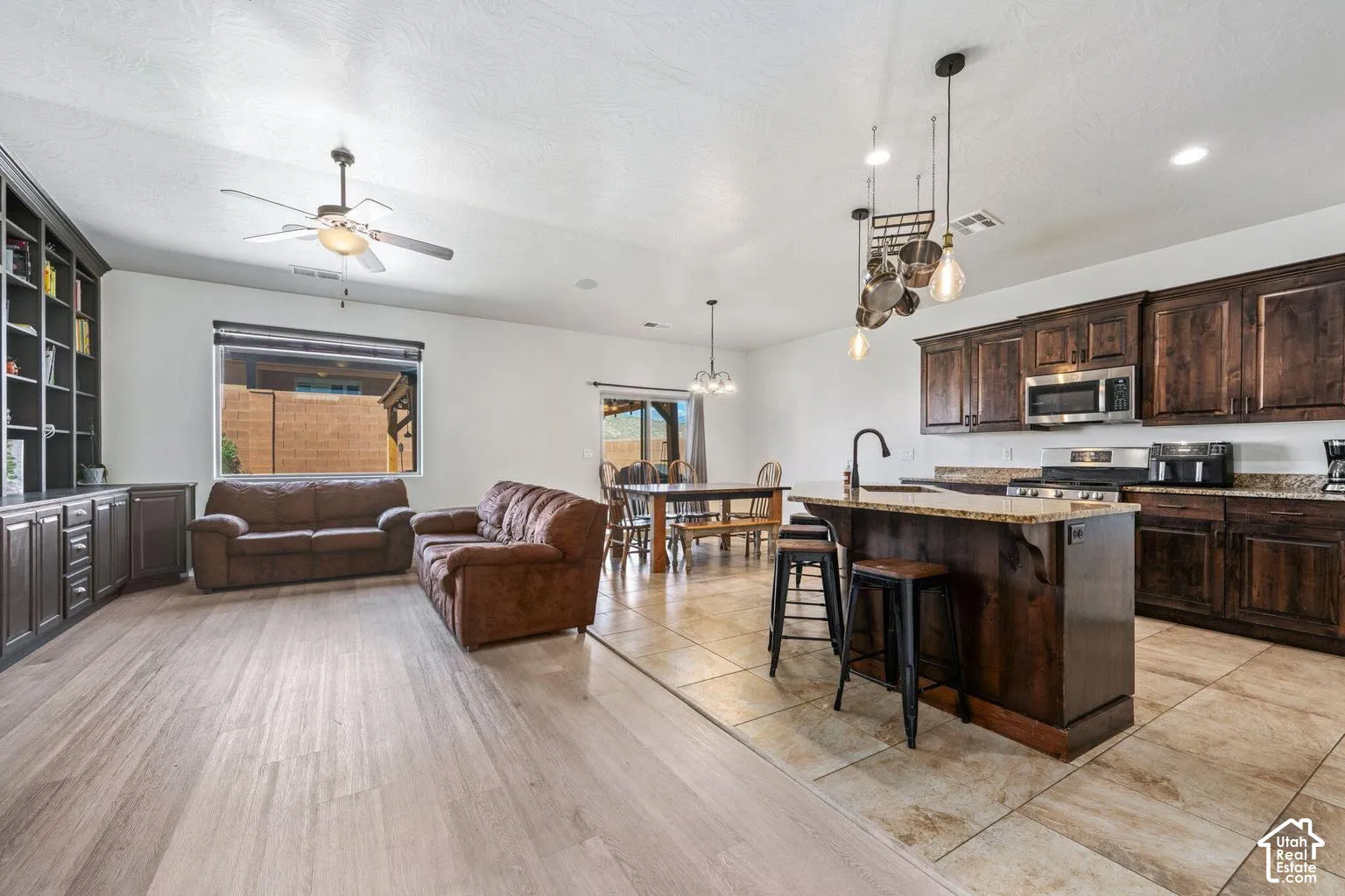 Open-concept living area featuring wood-finish flooring, built-in cabinetry, and a ceiling fan