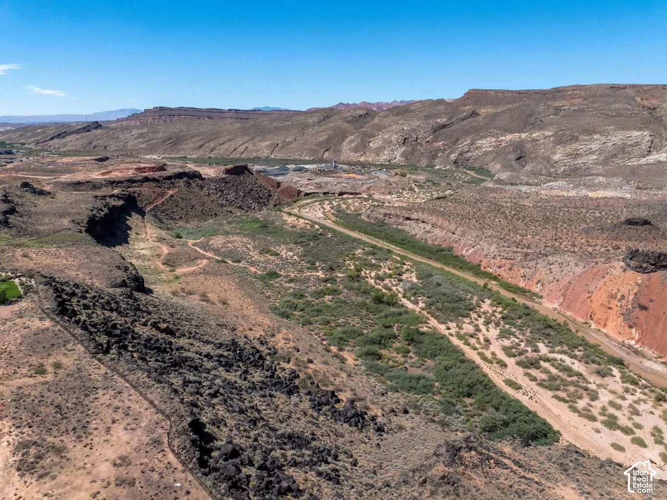 Expansive desert landscape featuring rock formations, varied terrain, and distant mountains