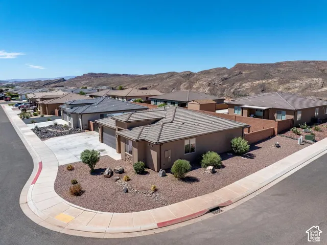 Contemporary stucco exterior with a tiled roof, integrated two-car garage, and desert-inspired landscaping