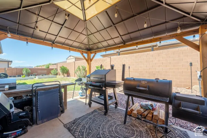 Outdoor patio with a gazebo, concrete flooring, and string lighting