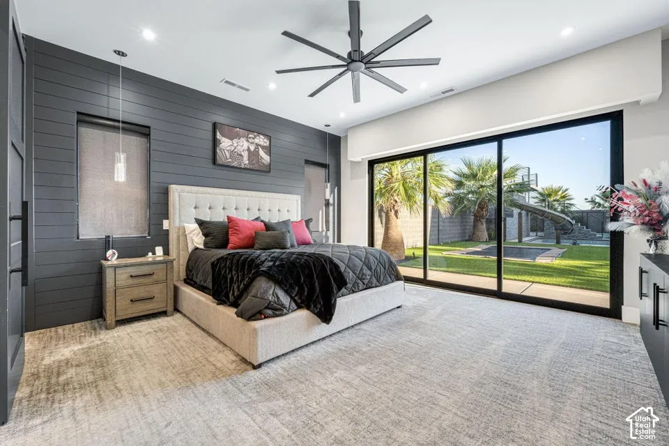 Wall-to-wall carpeting, shiplap accent wall, built-in recessed lighting, contemporary ceiling fan, and expansive sliding glass doors