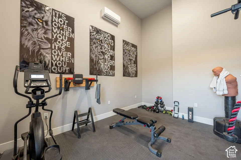 Specialized fitness area featuring a durable rubber-finish flooring, a wall-mounted air conditioning unit, and a built-in wall rack
