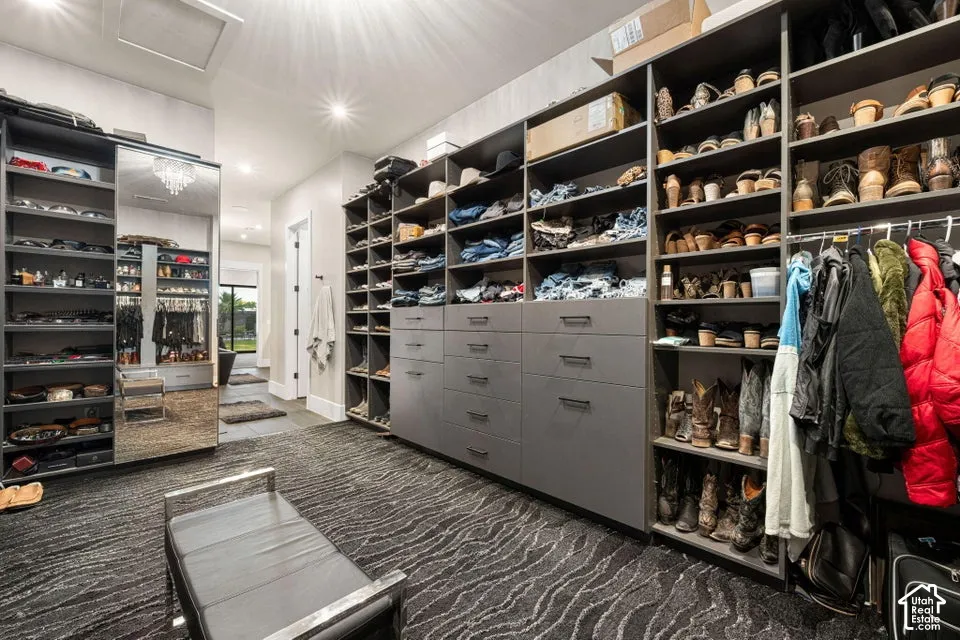 Recessed lighting illuminates extensive custom built-in cabinetry with integrated drawers, shelving, and hanging rods