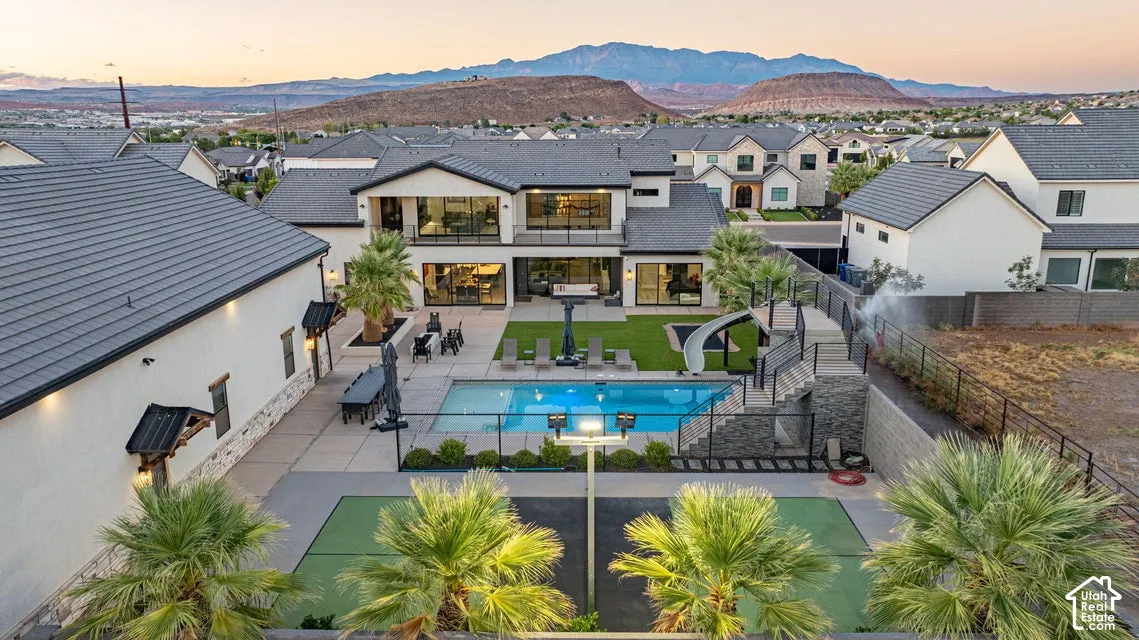 Expansive backyard with a swimming pool, integrated slide, and adjacent sport court