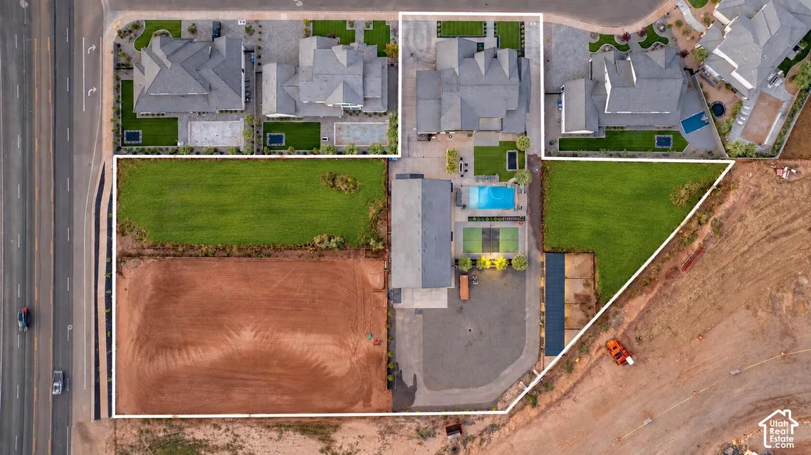 Large parcel offering a combination of cultivated land and undeveloped space, with nearby residential properties featuring pools and tennis courts