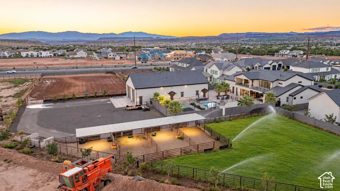 Multiple-building property with a large white barn, fenced equestrian stalls, and a swimming pool