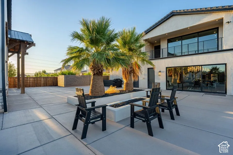 Expansive concrete patio featuring a built-in fire pit with decorative rock