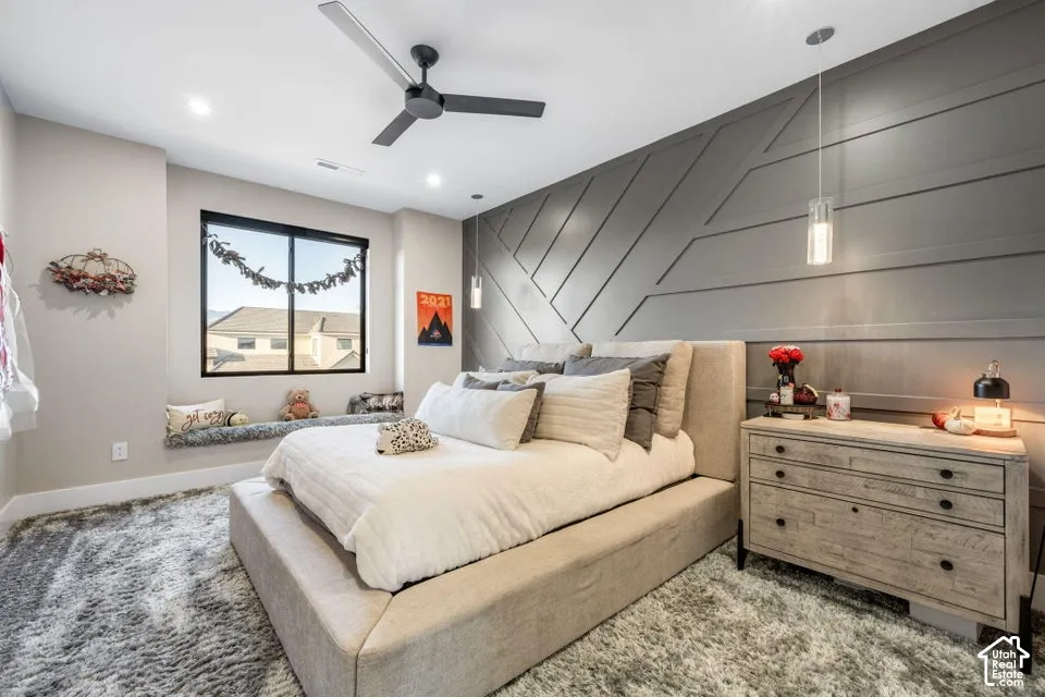 Accent wall with geometric paneling, recessed lighting, and a modern ceiling fan