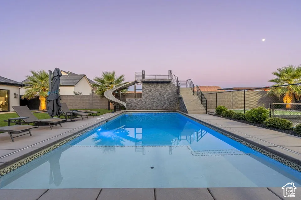 Rectangular swimming pool with integrated slide and deck