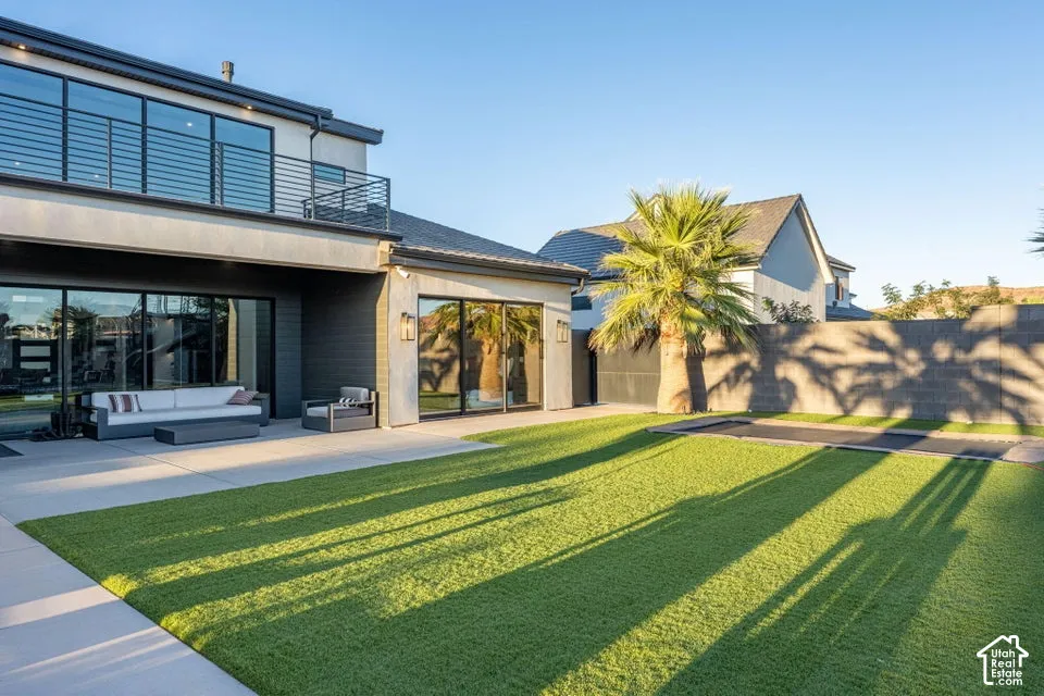 Expansive patio with direct access to interior spaces, featuring a modern exterior with large windows and a second-story balcony