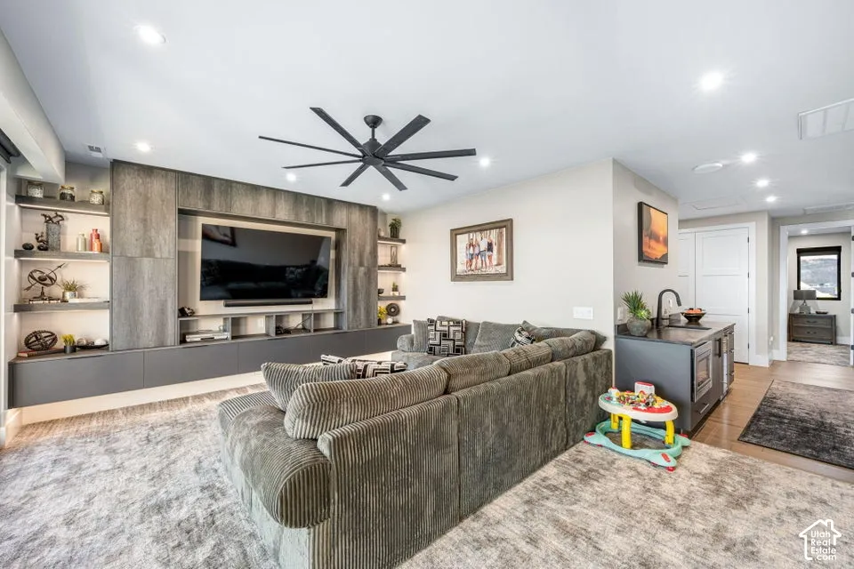 Open-concept living space anchored by a custom wood-finish entertainment wall with integrated shelving and media nook
