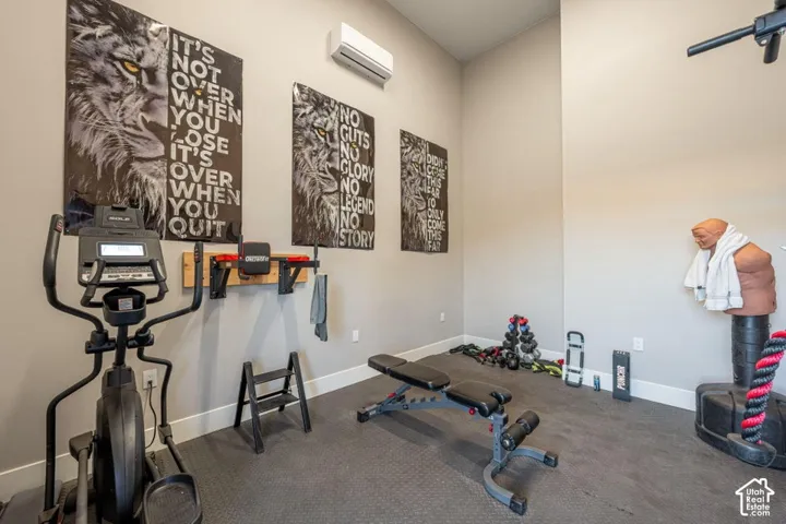 Specialized fitness area featuring a durable rubber-finish flooring, a wall-mounted air conditioning unit, and a built-in wall rack