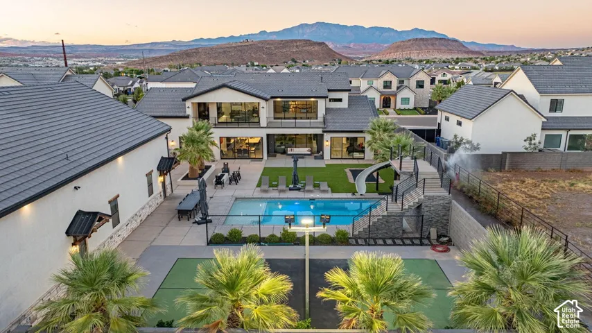 Expansive backyard with a swimming pool, integrated slide, and adjacent sport court