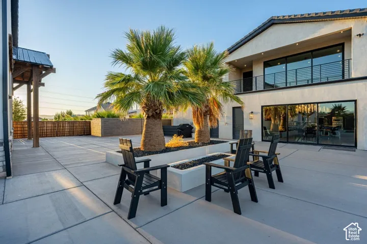 Expansive concrete patio featuring a built-in fire pit with decorative rock